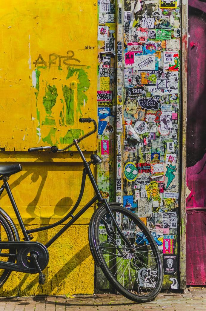 bike parked beside wall full of stickers